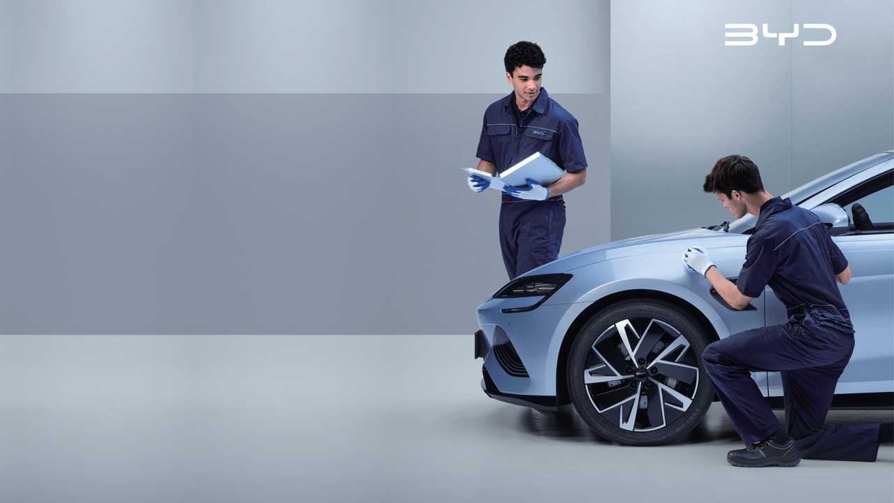 Deux mécaniciens BYD travaillant sur la carrosserie d'une BYD Seal