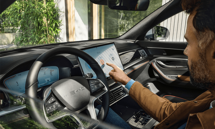 Homme au volant de son Seal U DM-I, utilisant la tablette numérique sur le tableau de bord 